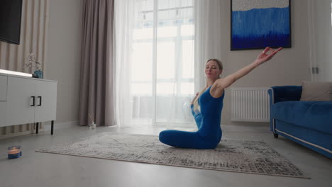 young-woman-is-practising-yoga-at-home-relaxing-in-simple-body-position-sitting-on-floor-with-beautiful-furniture-around.-slim-woman-in-sportswear-standing-on-knees-bending-back-and-doing-camel-pose